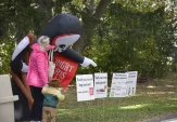 A family visiting ScaryFest at Markham Musem pointing at an inflatable grim reaper.