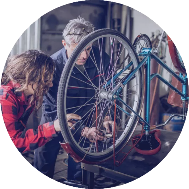 couple of people working on a bicycle 